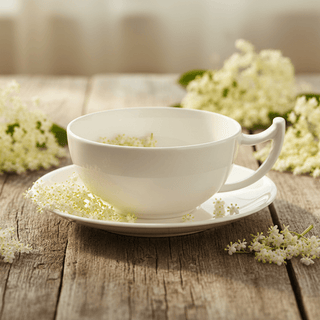 Jumbotasse „Epsilon", 0,35 l, Bone China auf Holztisch mit Holunderblüte